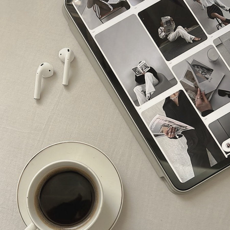 A tablet showing a content grid beside a cup of coffee